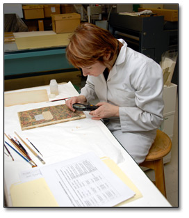 Photo: A conservator disbanding a 19th century journal