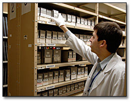 Photo: An archivist retrieving glass plate negatives from the special collections stacks
