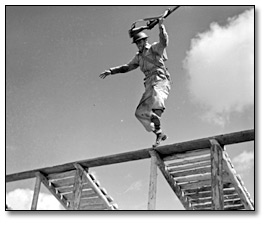 Photographie : Soldier jumping from obstacle during training, [vers 1945]