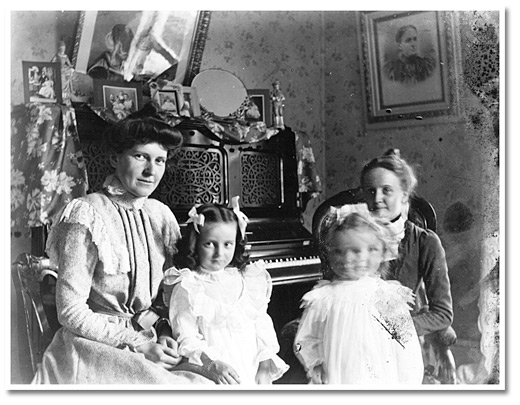 Photographie : La famille Clow à l’intérieur de leur maison, devant le piano,  [entre 1898 et 1920]