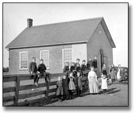 Photographie : Enseignantes et enfants se tenant devant une école, 25 janvier 1906