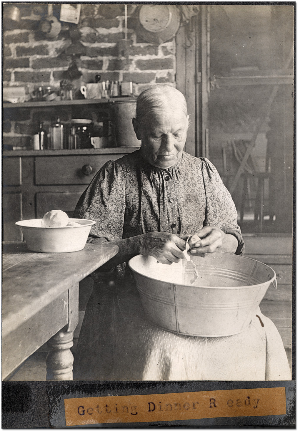Photo: Domestic servant getting dinner ready,1906