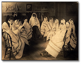 Photo: Children wrapped in blankets waiting for a visit from the school nurse, [ca. 1905]