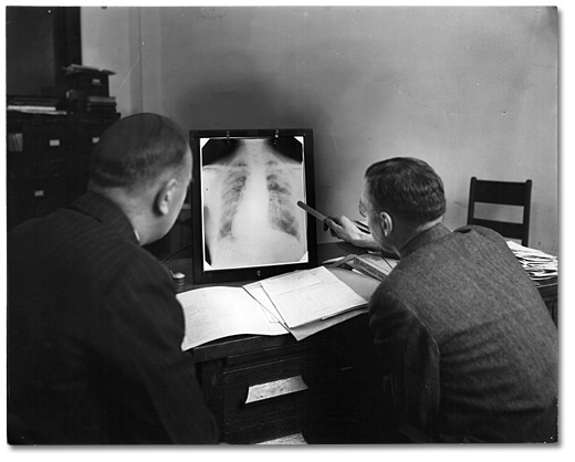Photographie : Deux hommes examinant une radiographie pulmonaire dans un laboratoire du Conseil de santé. Toronto, [vers 1928]