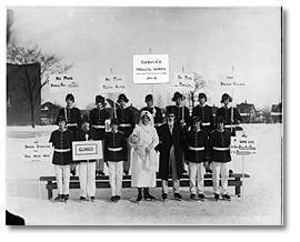 Photographie : Patineurs en costume d’apparat et tenant des affiches annonçant la Semaine de la santé à Sarnia. Janvier 1925