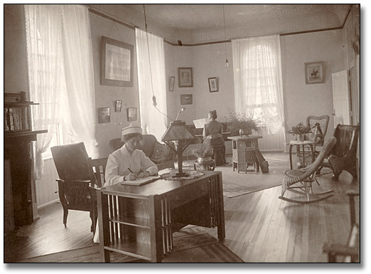 Photographie : Infirmière assise à un bureau, hôpital psychiatrique de Kingston, [vers 1900]