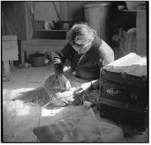 Photo: Woman at Fort Severn mending a gill net, 1955