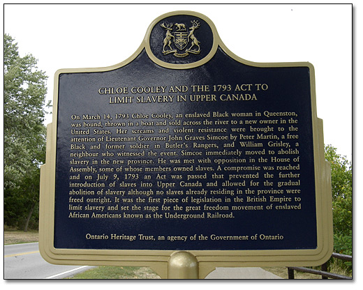 Cette plaque, située le long de la promenade Niagara à Niagara-on-the-Lake marque l’endroit où Chloe Cooley fut forcée à traverser la rivière pour être vendue