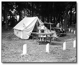 Photographie : Girl standing in front of a tent at a tourist camp in Midland,  [ca. 1915]