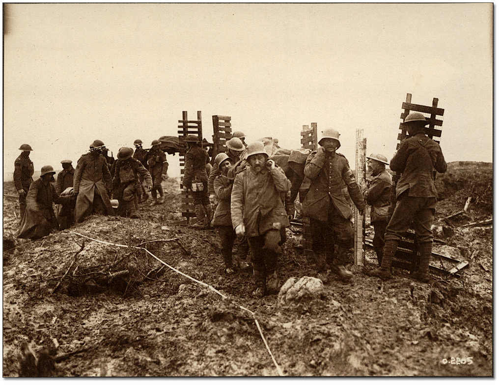 Canadian Pioneers carrying trench material to Passchendaele quiting work while German prisoners carrying wounded pass by, 1917
