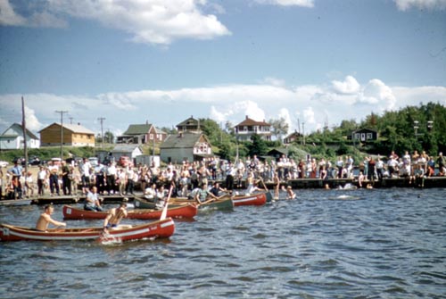 Canoes in the water with spectators on shore during regatta, Sioux Lookout, [ca. 1953]