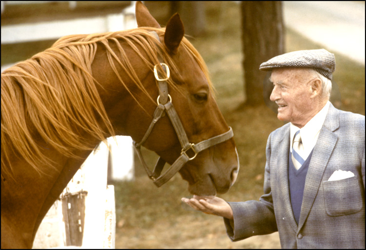 Conn Smythe greets one of his horses, [ca. 1975]