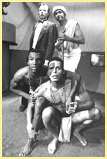 Cliquez pour Quatre acteurs regardant au loin. Trois hommes de couleur portant un revêtement en tissu et un homme blanc en smoking
