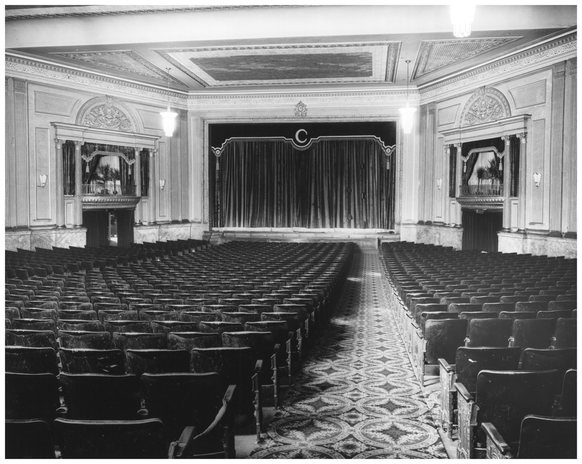 Intérieur du théâtre Capitol à Chatham (Ontario). Auditorium vide en direction de la scène, avec le rideau fermé.