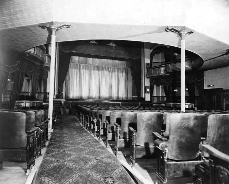Intérieur du Grand Theatre à Sudbury (Ontario). Auditorium vide en direction de la scène, avec le rideau fermé.