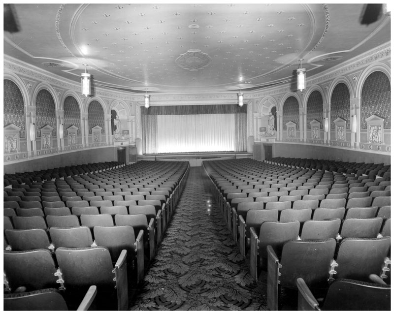 Interior of the Tivoli Theatre in Hamilton, Ontario. Empty auditorium looking towards stage with curtain closed.