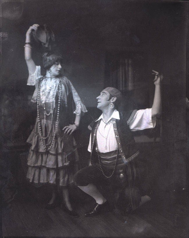 Actors K. McCarthy (standing at left) and Ernest Morgan (on one knee at right), both posed with one arm raised.