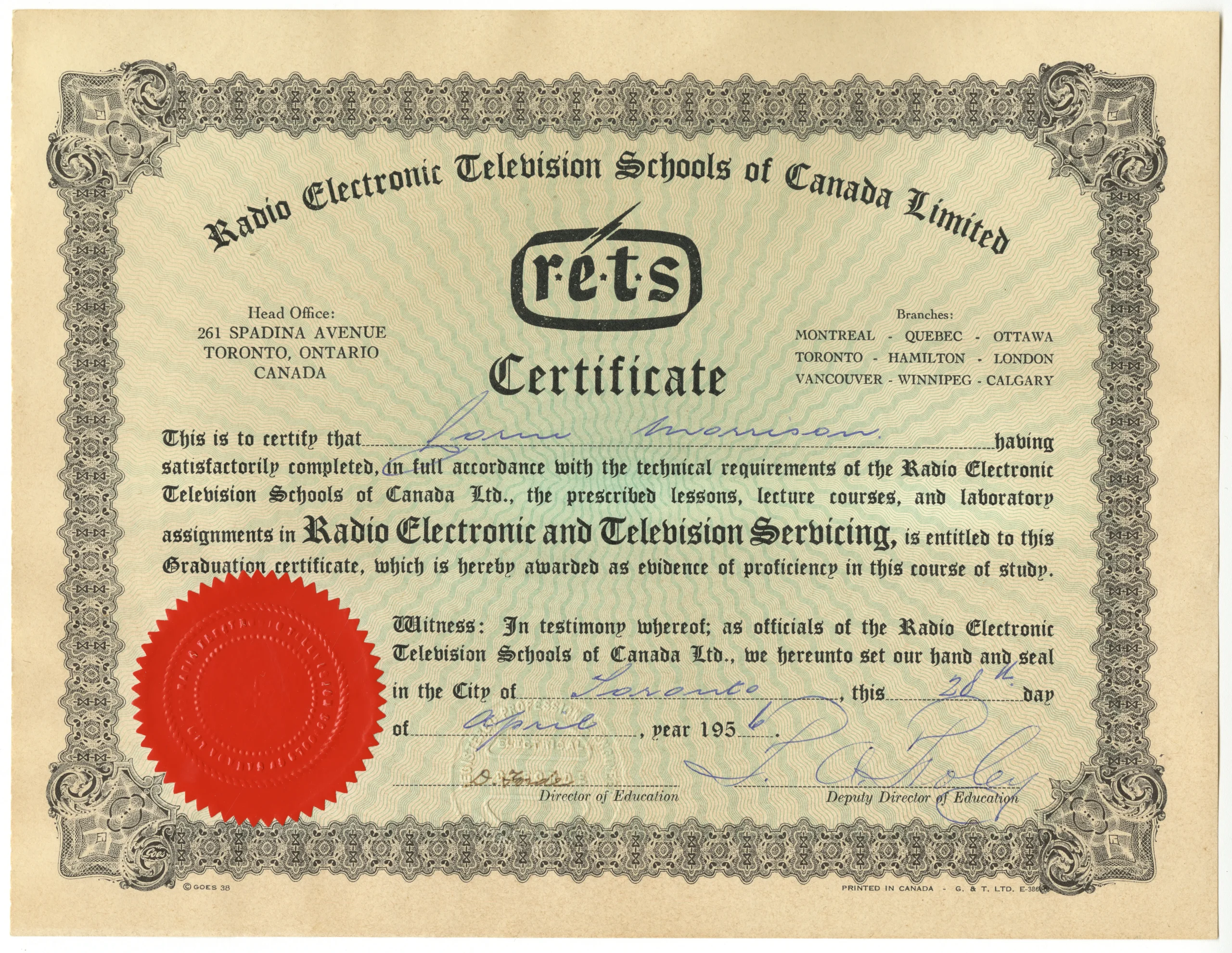 Photo couleur d’un certificat de couleur crème, comportant du texte imprimé, une bordure décorative imprimée, des signatures manuscrites et un grand sceau officiel rouge.