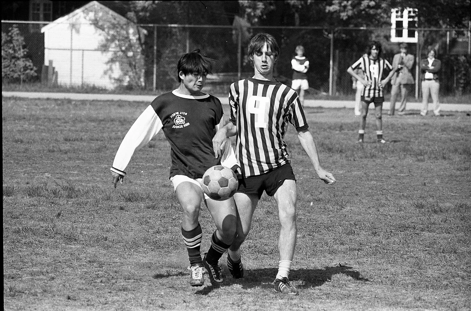 Neil McNeil vs. Power, Toronto, 1972 Black-and-white photo of two high school boys playing soccer and running down the field, with one player trying to gain control of the ball.