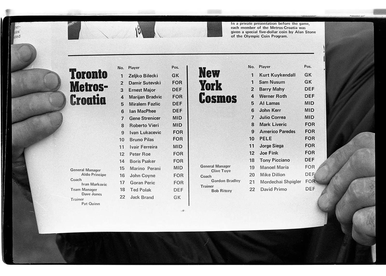 Black-and-white photo of two hands holding a score sheet from the 1975 game of the New York Cosmos vs. Toronto Metros.