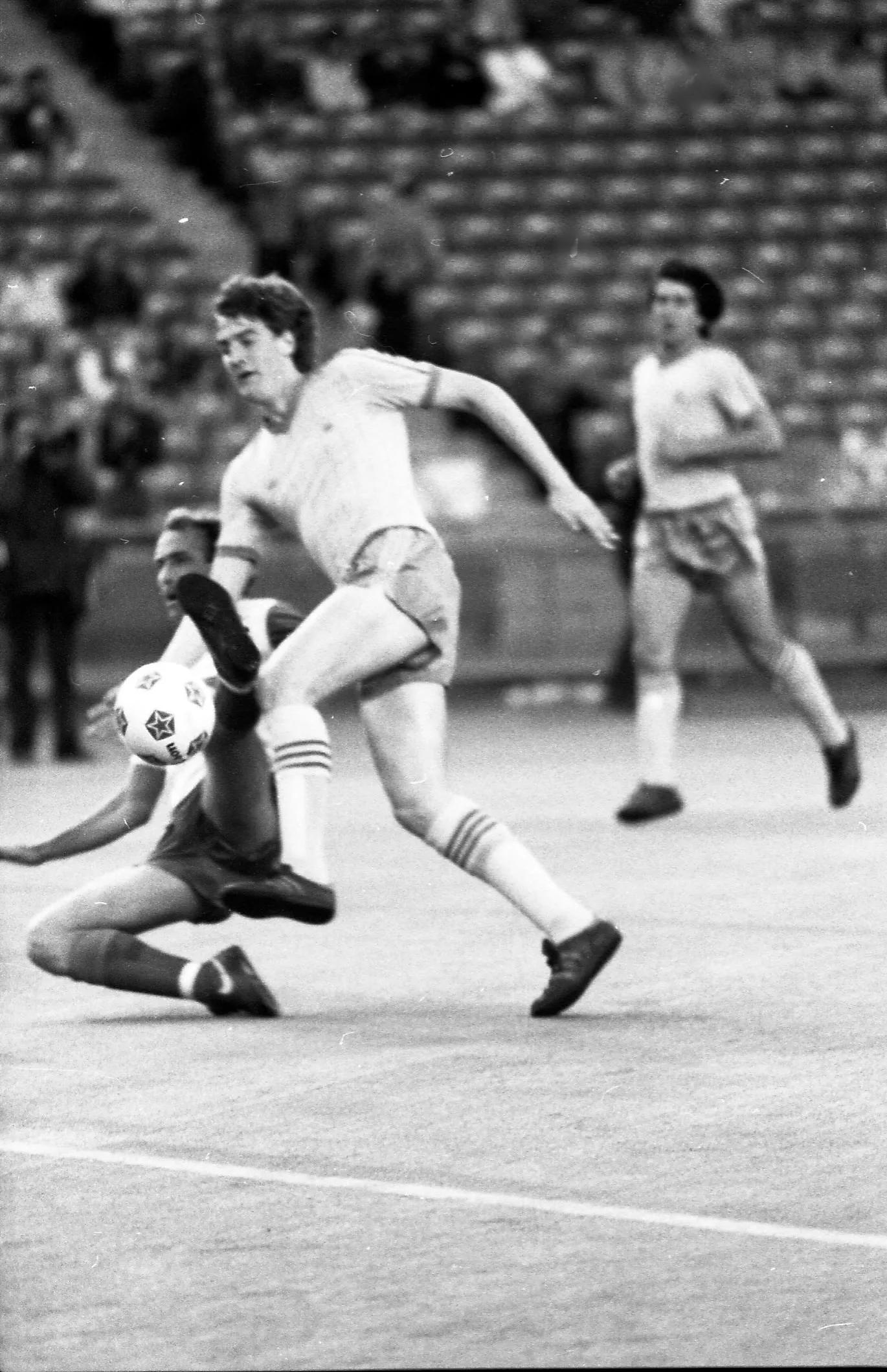 Black-and-white photo of a Toronto Blizzard player slide tackling a Nottingham Forest player.
