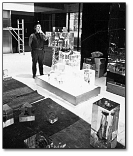 Phogographie : Gerald Gladstone installant sa sculpture, Galaxy Series #2 '67 [Galaxie, Série no 2 1967], dans le hall de l'édifice Macdonald, 1968