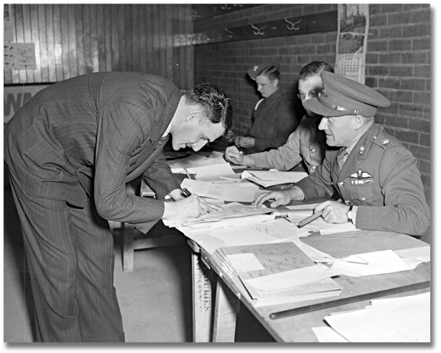 Photo: Ted Reeve (Toronto Telegram Sports writer) enlisting for Sportsmen Battery with Conn Smythe at Maple Leaf Gardens, 1939