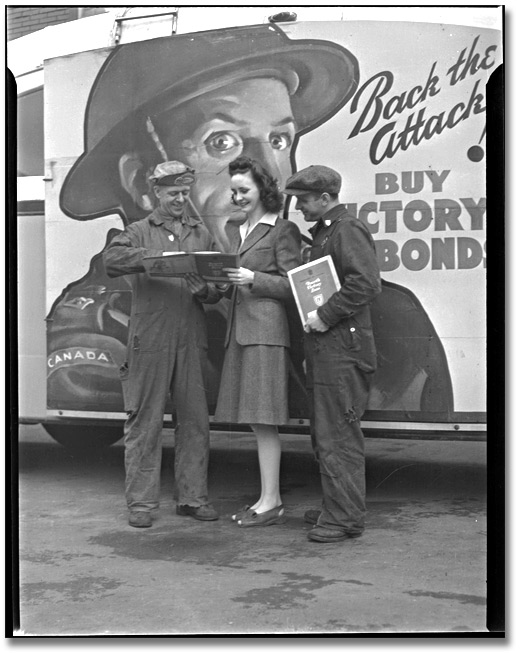 Photo: Woman talking to shipbuilding workers about Victory Bonds, Toronto, [ca. 1945]