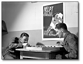 Photo: Dutch troops [playing board game; Dutch war poster in background], April 1941