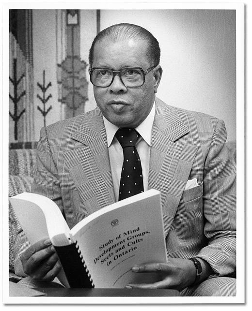Photo: Daniel G. Hill with cult study he authored, 1980