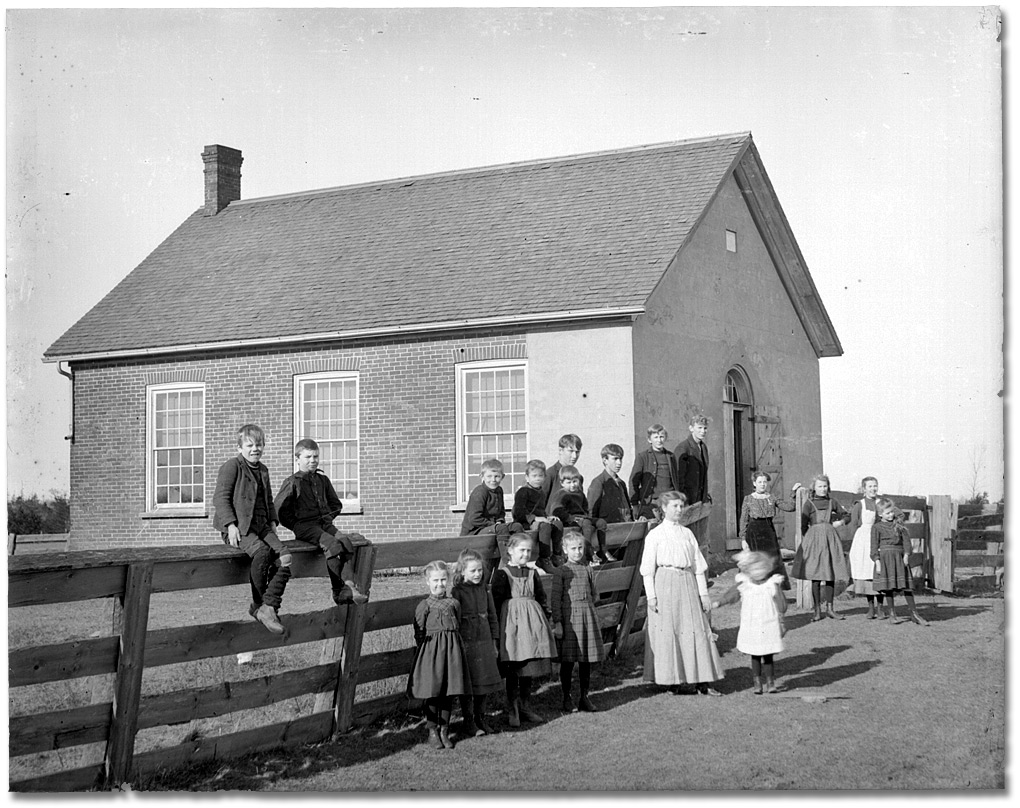 Photo: Teachers and children posing outside a schoolhouse, January 25, 1906