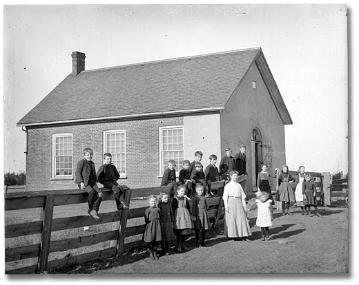 Photographie : Enseignantes et enfants se tenant devant une école, 25 janvier 1906