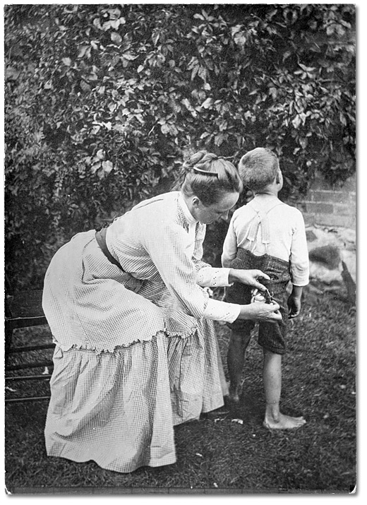 Photographie : Mère cousant les pantalons d’un jeune garçon, 1904