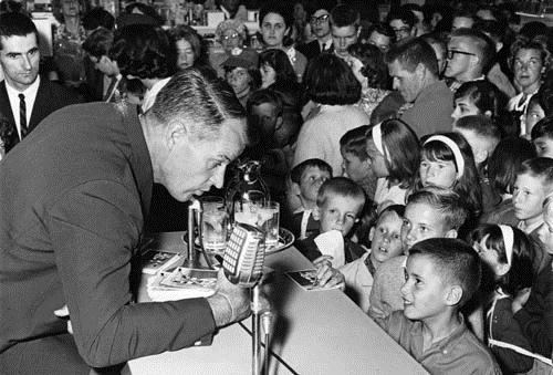 Gordie Howe speaking to children at an Eaton's sporting goods promotion event, 1964