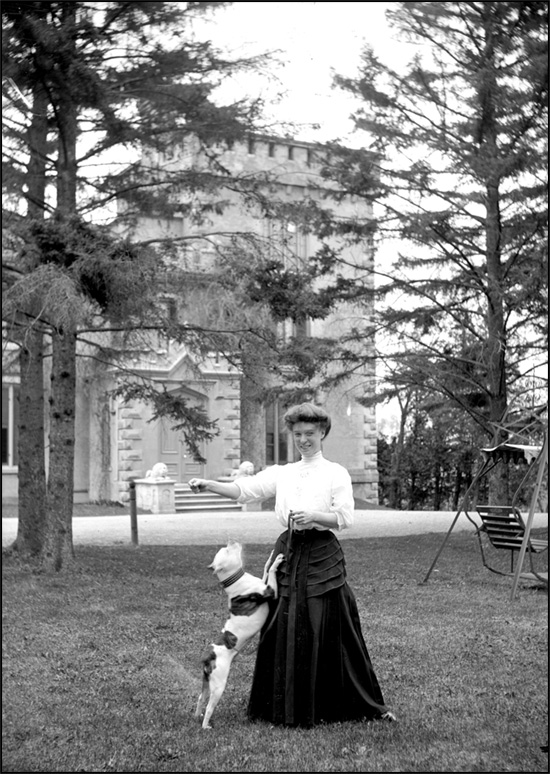 Mrs. Hepburn and dog standing in front of Rickarton Castle, Picton, Ontario, [between 1898 and 1910] 