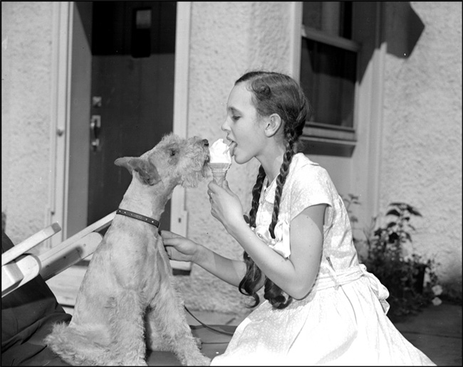 Pianist Patsy Parr eating ice cream with a dog, August 10, 1949