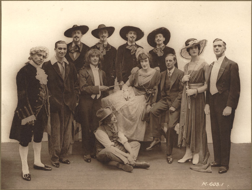 La troupe de théâtre The Dumbells. Douze hommes en costume, deux déguisés en femmes.
