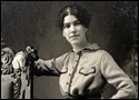 Black and white photograph of a woman, from the waist up, posing for the camera