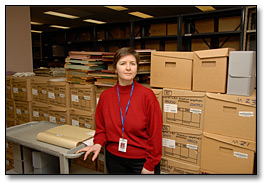 Photo: Archivist standing with newly received boxes