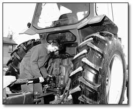 Photographie : Fermière au travail sur un tracteur, 28 mars 1984