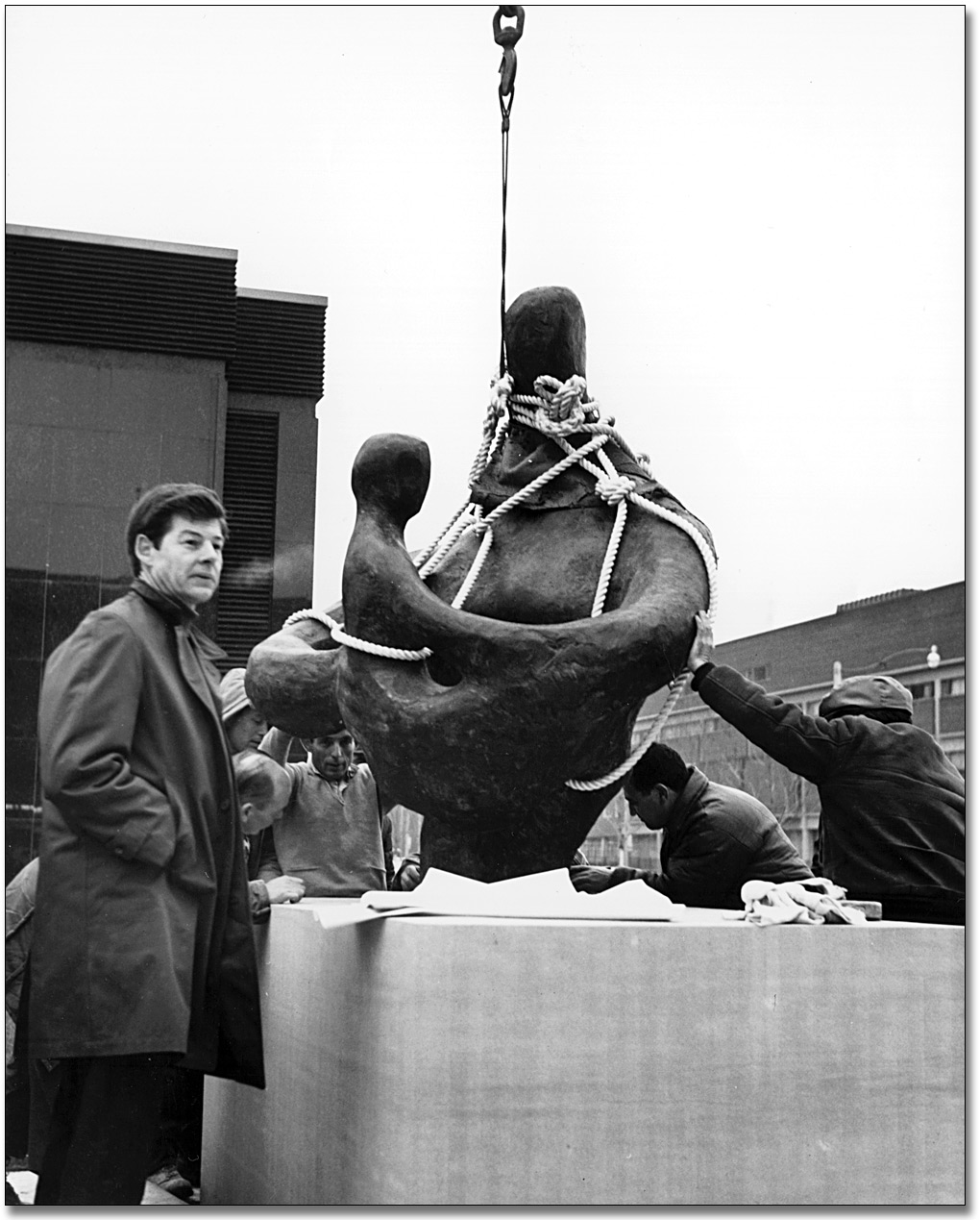Photographie : Jack Harman supervisant l'installation de sa sculpture, Mother and Child, dans la partie ouest de l'édifice Macdonald, 1968