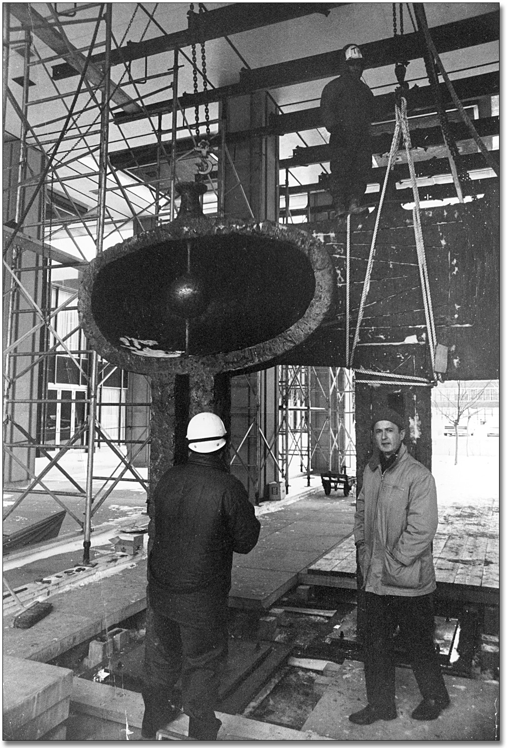 Photographie : Louis Archambault supervise l'installation de sa sculpture, Homme et Femme, à l'extérieur de l'entrée de l'édifice Hepburn, 1968