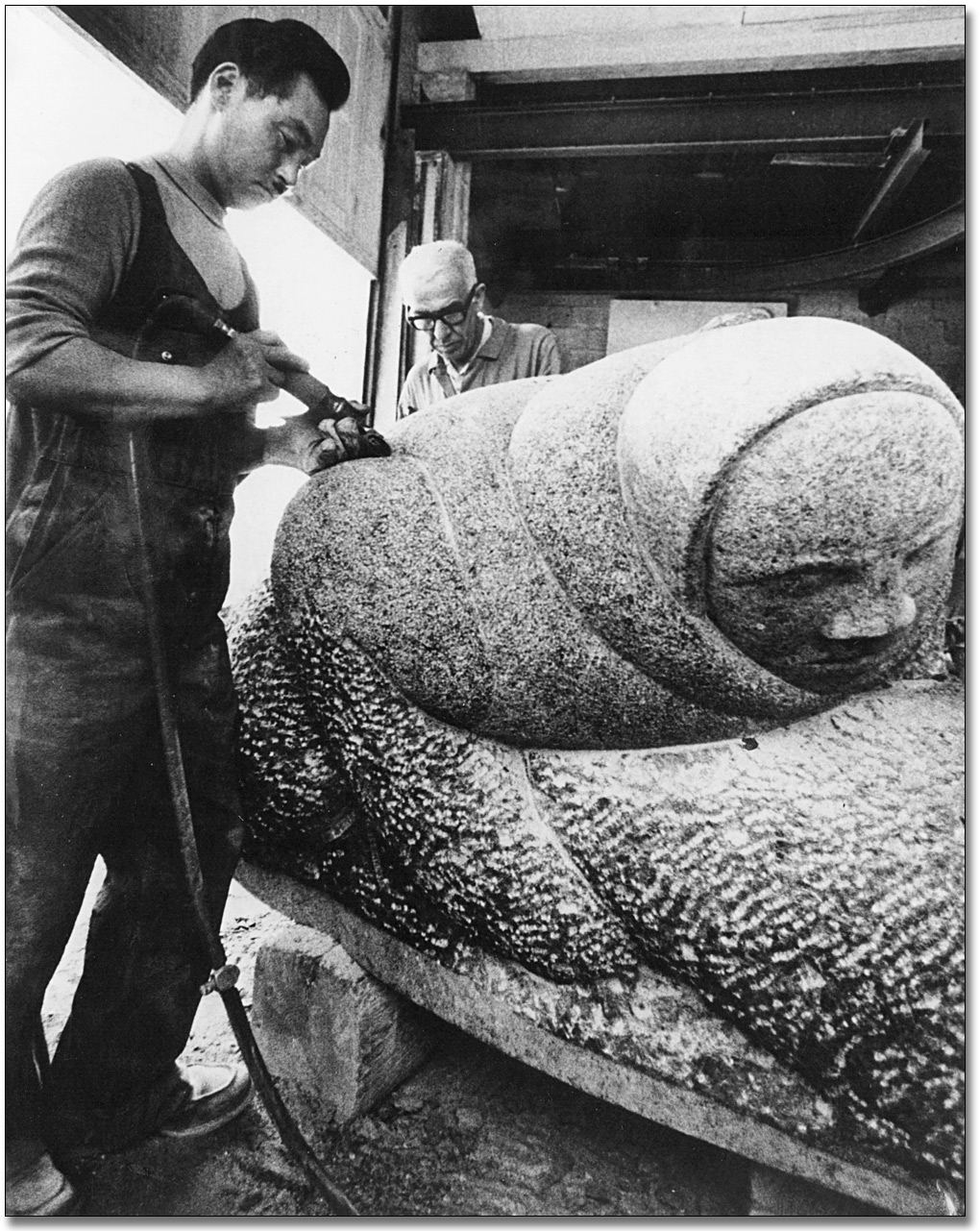 Photographie : Paulosie Kanayook travaillant sur sa sculpture, Hunter With Seal [Le chasseur et le phoque], 1968