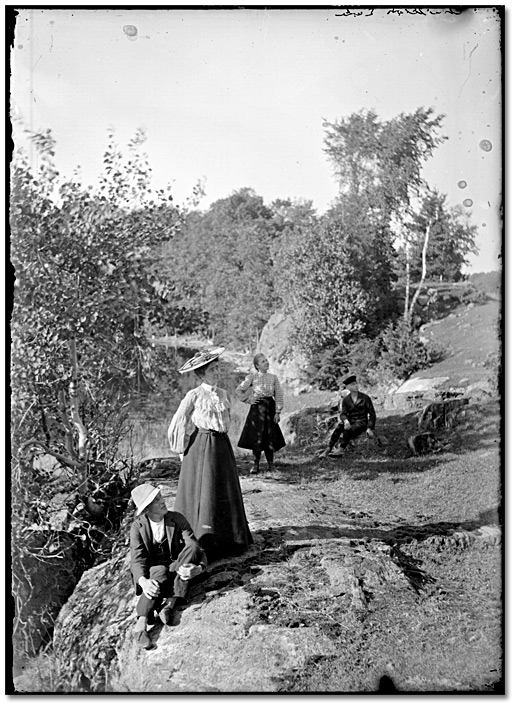 Photo: Two men and two women on rocky outcrop at Charleston Lake, [ca. 1919]